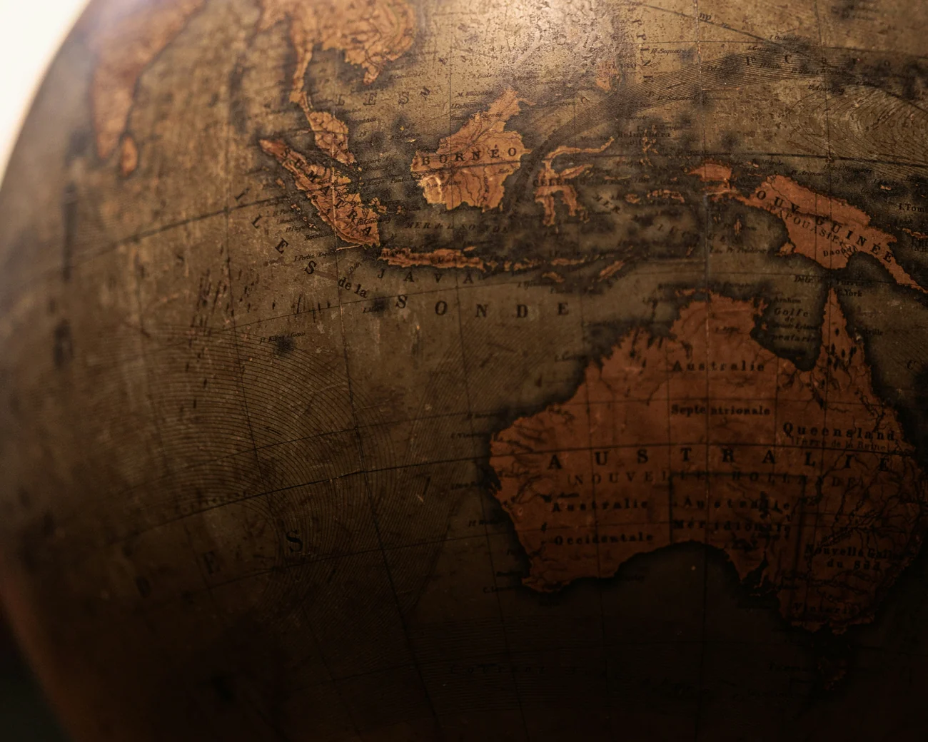 A worn antique globe turned to Asia and the Pacific